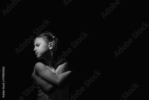 Portrait of crying young girl. Loneliness, pain, child tragedy. Black and white image. Horizontal image.
