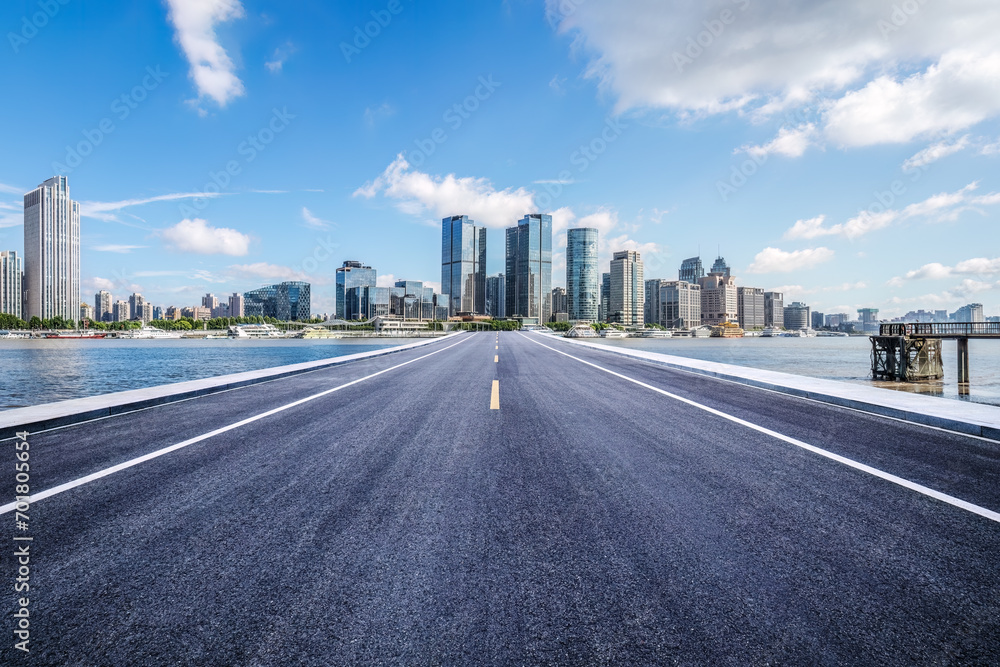 Empty asphalt road and city buildings skyline