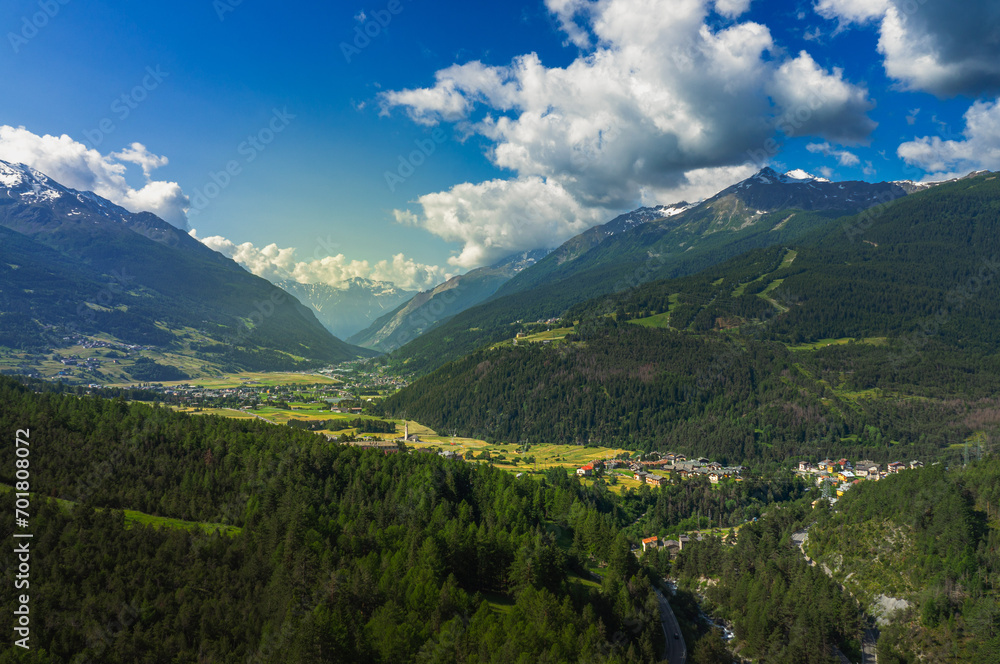 beautiful panorama of an Italian valley during springtime with the sun illuminating the valley and the blue sky