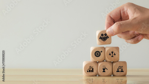 Business teamwork and partnerships concept. Hand putting hand shaking which print screen on wooden cube block. Business collaboration strategies, agreement, deal and finance and investment.