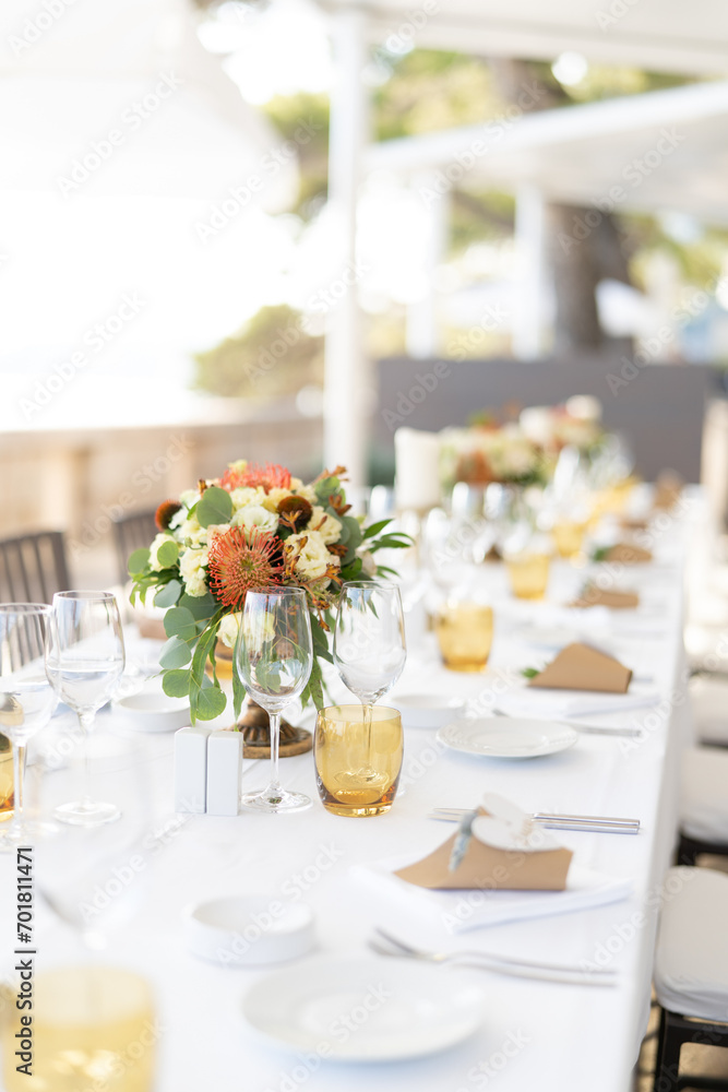 Long table set with bouquets of flowers and invitation succulents