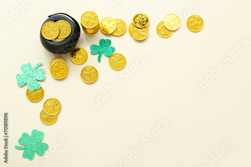 Pot with coins and paper clovers on beige background. St. Patrick's Day celebration