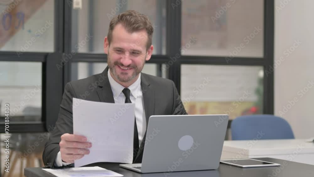 Businessman Celebrating while Doing Paperwork Businessman Celebrating while Doing Paperwork