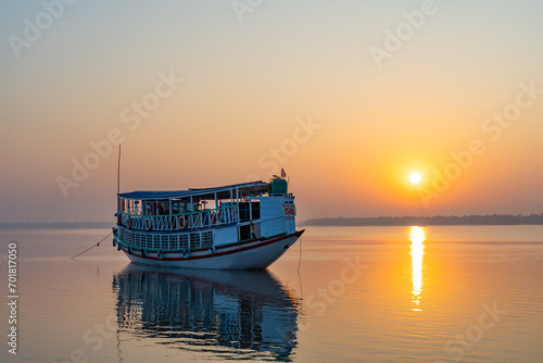 Abstract Sunset over boat in a sea. Natural background landscape. Dramatic sky and reflection on water during sunrise in Sundarbans.