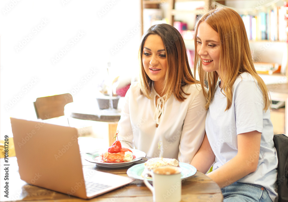 Cheerful women making video call in cafe