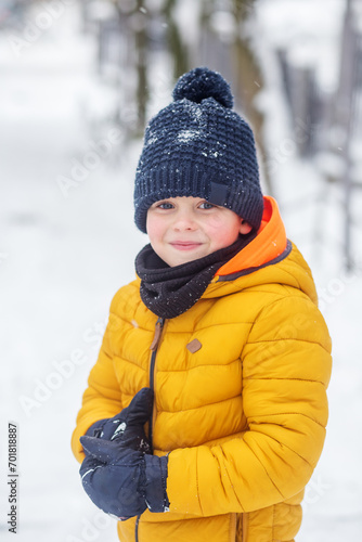 Winter games outdoors. Portrait of kid boy wearing scarf and hat, winter time.