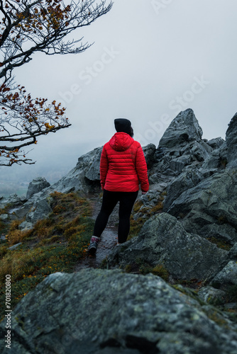 Frau mit roter Jacke in den Bergen genießt den Ausblick