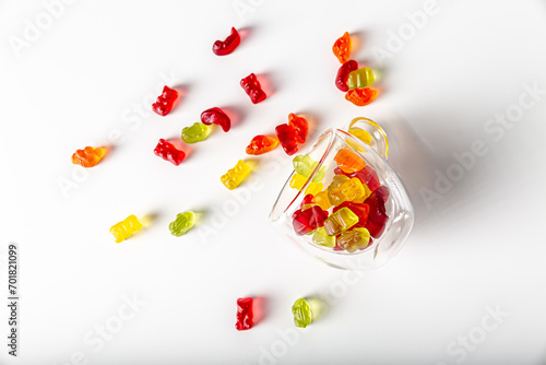 Tasty gummy jelly bears, isolated on white background. Colorful gummy jelly bears in a transparent glass cup photo