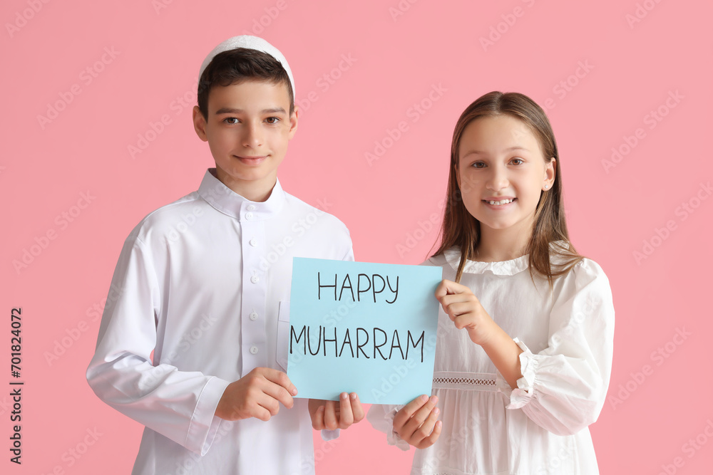 Little Muslim children with greeting card for Islamic New Year on pink background Little Muslim children with greeting card for Islamic New Year on pink background
