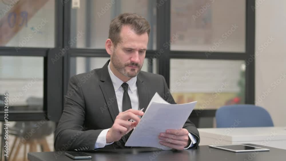Businessman Reading Business Report at Work Businessman Reading Business Report at Work