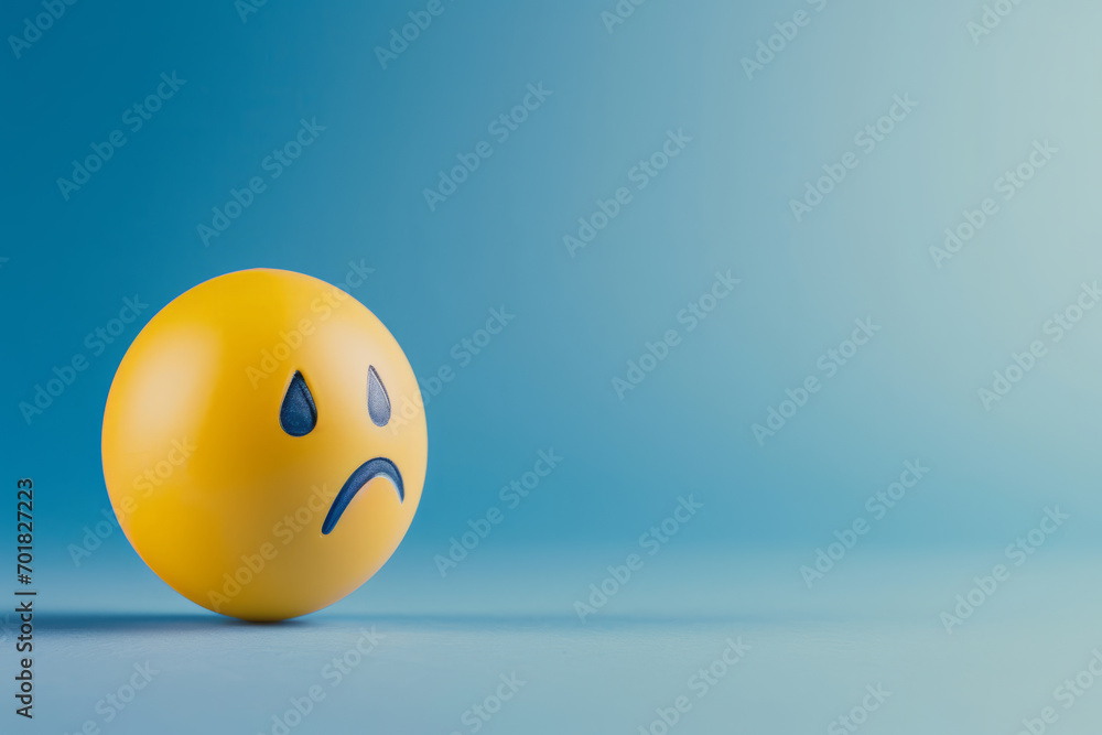 Blue Monday concept. Yellow sad emoji face on light blue background Blue Monday concept. Yellow sad emoji face on light blue background