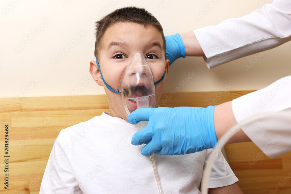 The boy is preparing for the nebulizer inhalation procedure.