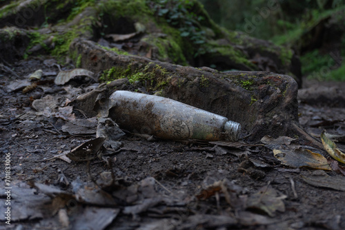 Basura en el bosque, botella de cristal tirada en el bosque