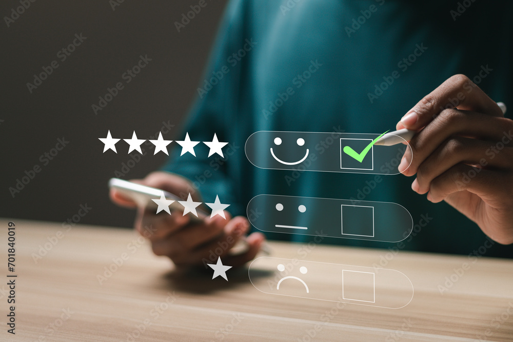Customer satisfaction service concept. Businessman rate satisfaction by smiling face and 5-star satisfaction, on online application. satisfaction feedback review, good quality most. - obrazy, fototapety, plakaty 