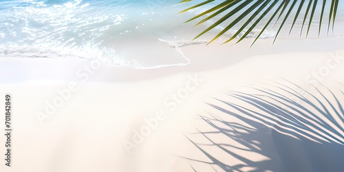 palm leaf shadow on abstract white sand beach background with sunlight in transparent water wave from above, beautiful summer vacation concept with copy space