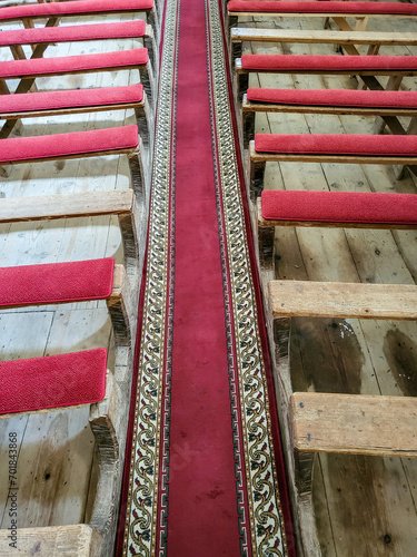 Interior view of the church with wooden benches with red velvet coverings and an old altar with an organ in the Biserica Evanghelica Fortificata Viscri, Deutsch-Weisskirch, Brasov, Transylvania, Roman photo