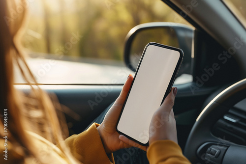 Closeup driver hand is holding smartphone with white screen