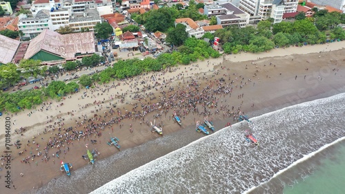 Pangandaran Beach, West Java, Indonesia. A stunning scene where a group of tourists celebrate the beauty of nature while enjoying the hajat laut, an interesting cultural procession.
