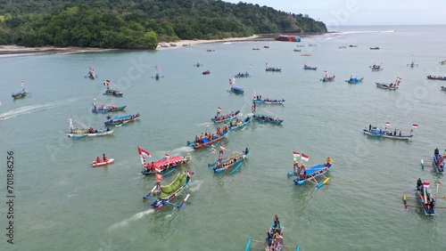Pangandaran Beach, West Java, Indonesia. A stunning scene where a group of tourists celebrate the beauty of nature while enjoying the hajat laut, an interesting cultural procession.