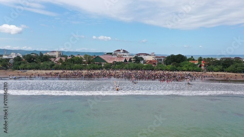 Pangandaran Beach, West Java, Indonesia. A stunning scene where a group of tourists celebrate the beauty of nature while enjoying the hajat laut, an interesting cultural procession. photo