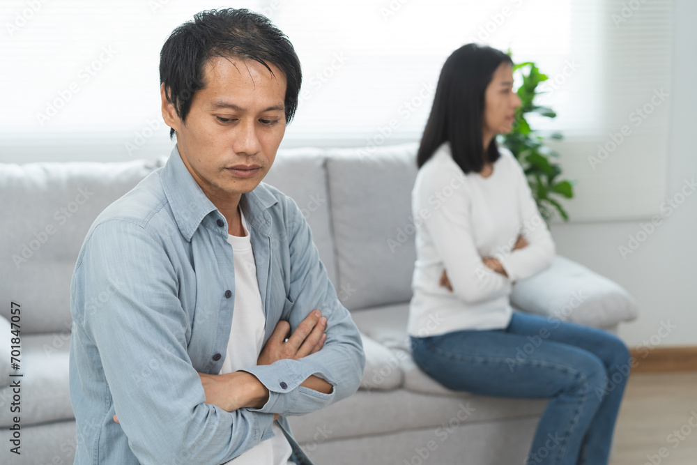 Family divorce problem concept, Husband and wife sitting separating after arguing in the living room at home.