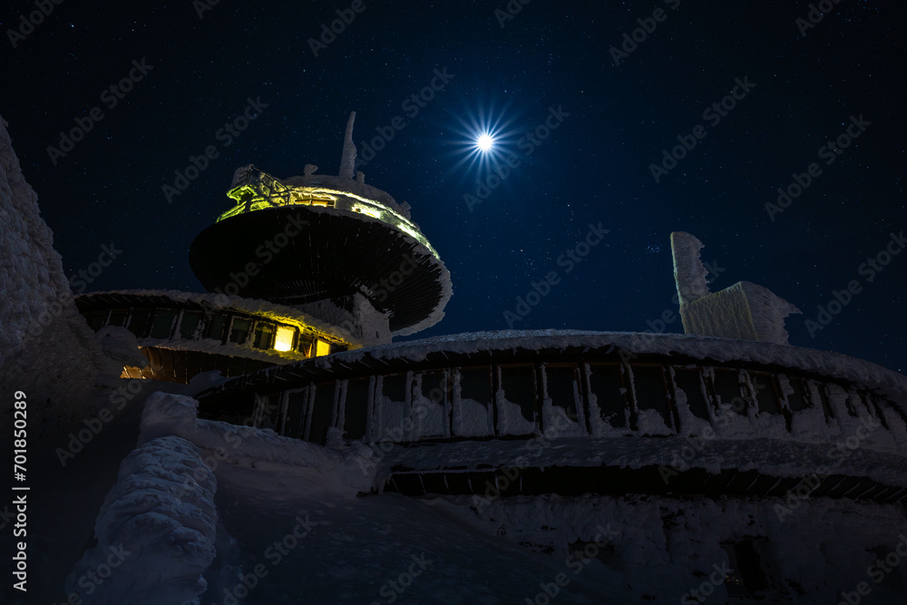 peak of Sniezka mountain at full moon night during in Giant mountains during winter