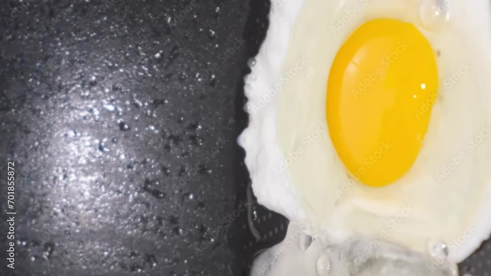 Delicious fried chicken eggs falling into the pan, close-up. Vertical video Delicious fried chicken eggs falling into the pan, close-up. Vertical video
