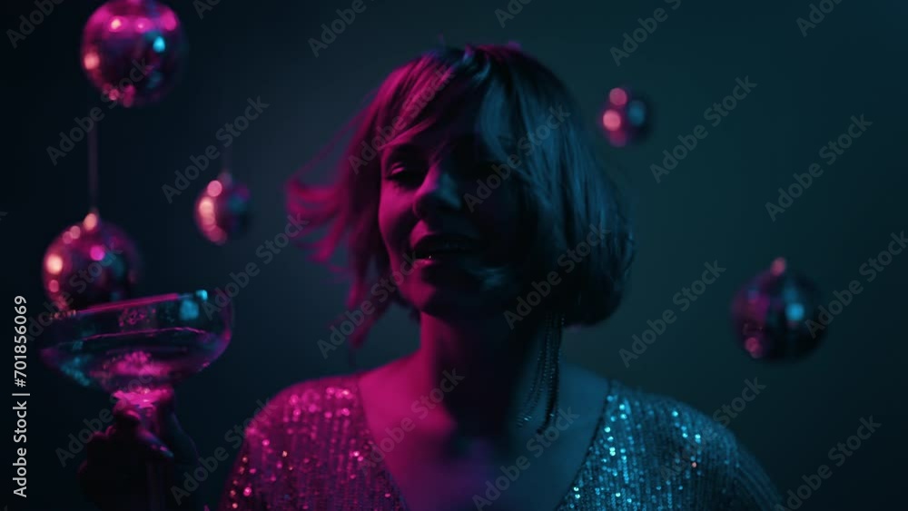 Pretty woman dancing with champagne glass, new year party, neon colorful light. Pretty woman dancing with champagne glass, new year party, neon colorful light.