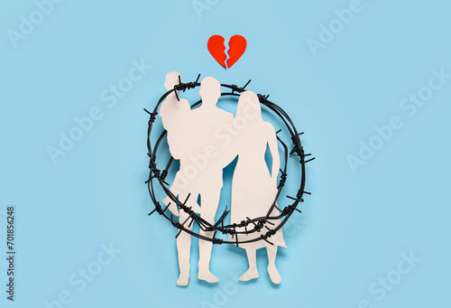 Torn heart with family figure and barbed wire on blue background. Domestic violence concept