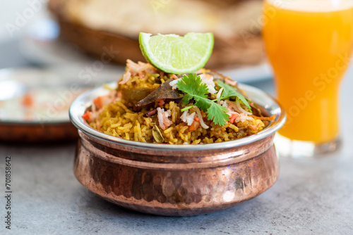 Spicy Indian biryani pulao in golden bowl with India basmati rice dish with chicken meat curry