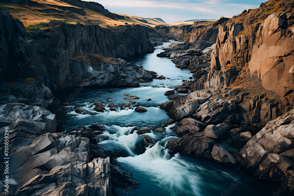 A winding river carves through rugged terrain, showcasing nature's formidable forces in action.
