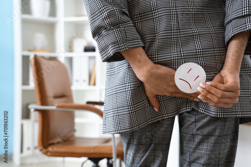 Photos Young businesswoman with hemorrhoids and sad smile in office, back view