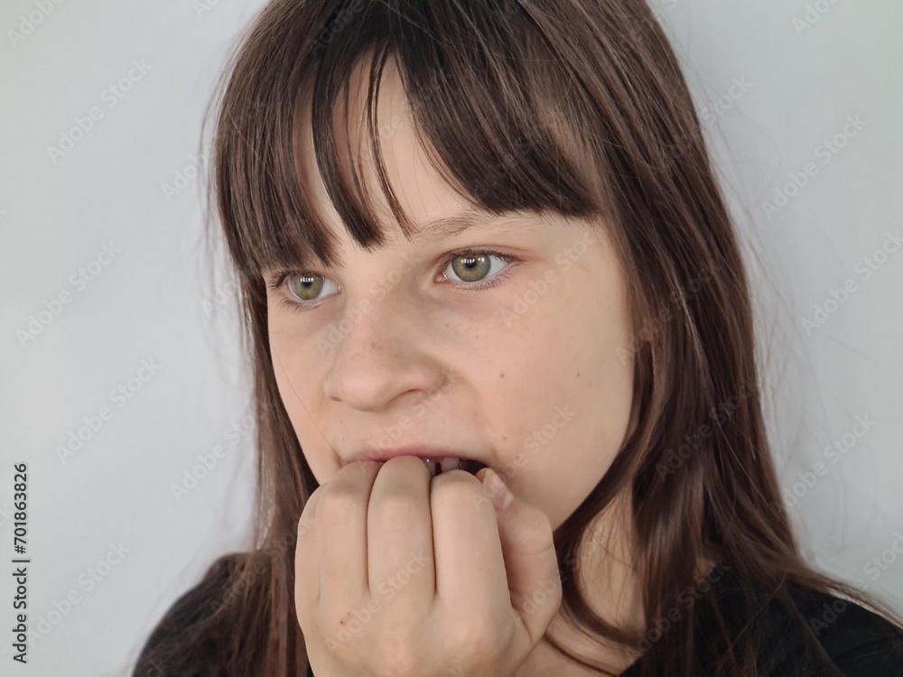 Cute child or girl bites nail with anxiety and thoughts Cute child or girl bites nail with anxiety and thoughts