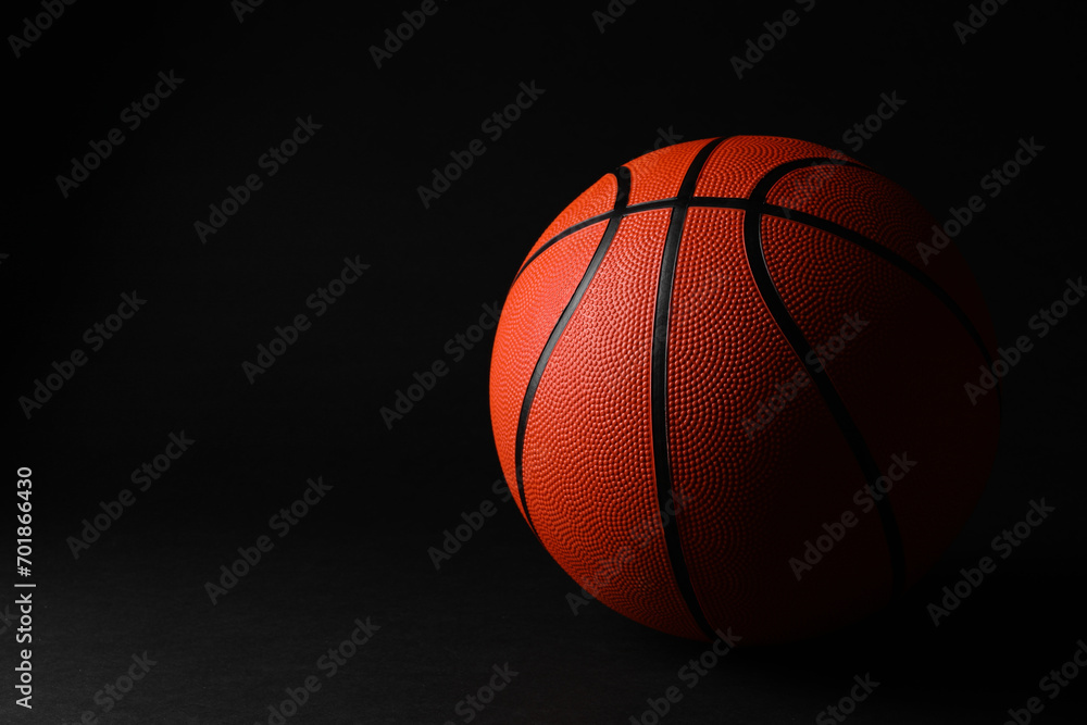 One basketball ball on black background. Space for text One basketball ball on black background. Space for text
