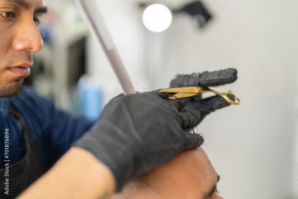 Barber cutting the hair of a client using manual scissors Barber cutting the hair of a client using manual scissors