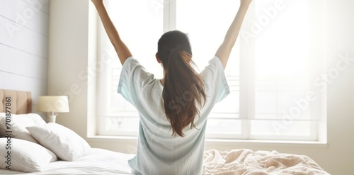 A Graceful Asian Woman Waking Up in a Simple White Room, Embracing the Morning Air with a Stretch. Generative AI photo