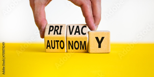 Privacy or autonomy symbol. Concept word Privacy or Autonomy on wooden cubes. Beautiful yellow table white background. Businessman hand. Business privacy or autonomy concept. Copy space. photo