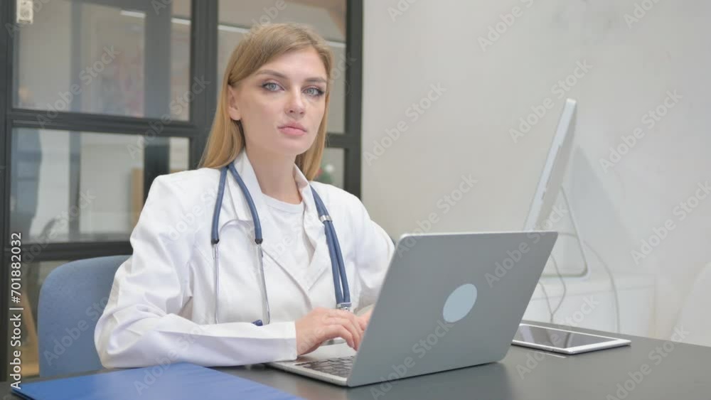 Female Doctor Looking at Camera while Working on Laptop Female Doctor Looking at Camera while Working on Laptop