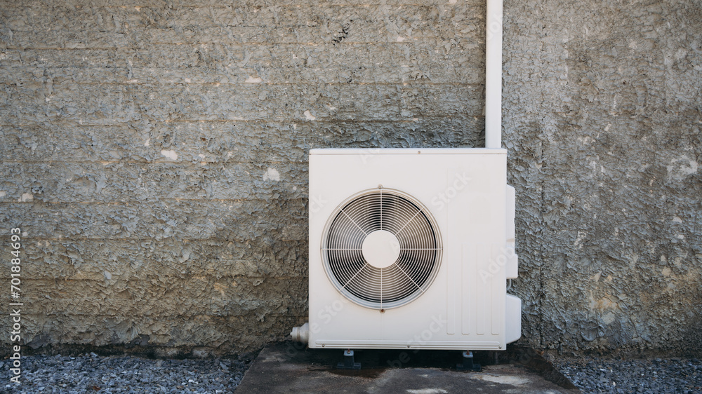 Air conditioner compressor installed on the wall of a building, along ...
