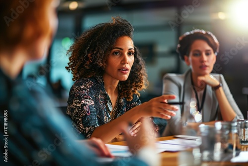 An experienced businesswoman leads a roundtable discussion, her authoritative yet approachable demeanor encouraging open communication and innovative thinking among her colleagues. photo