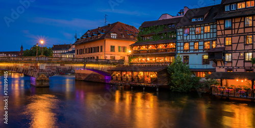 Fototapeta Naklejka Na Ścianę i Meble -  Ornate traditional half timbered houses with blooming flowers along the canals in the Petite France district of Strasbourg, Alsace, France at sunset