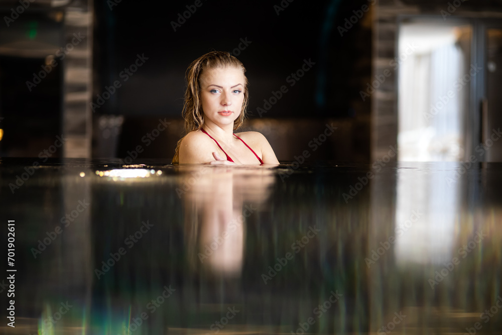 Serene woman relaxing in indoor pool
