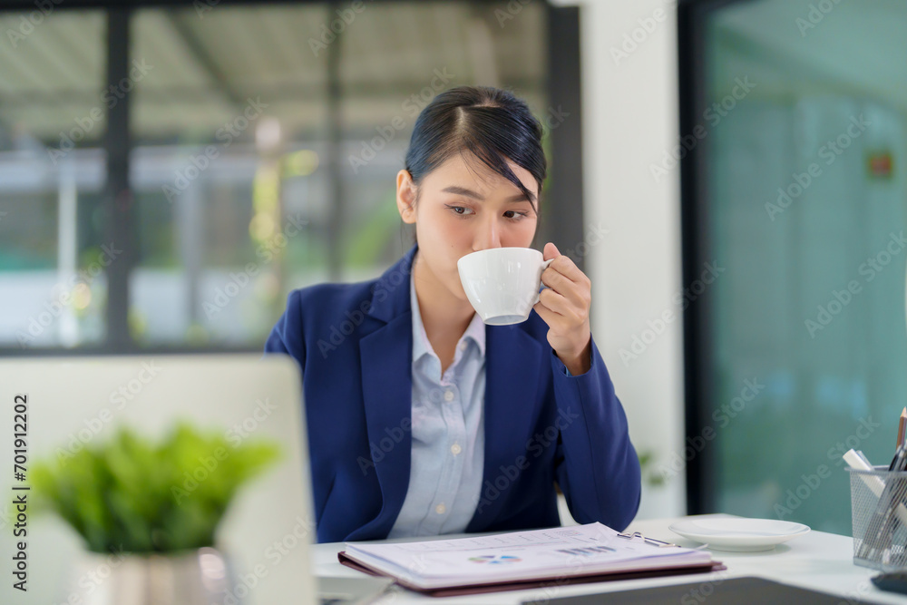 businesswoman working with laptop and documents while drinking coffee businesswoman working with laptop and documents while drinking coffee