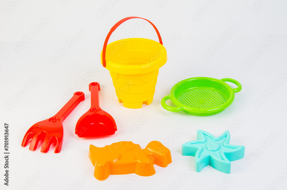 Children's plastic multi-colored set on a white background for playing in the sand on the beach. Children's plastic multi-colored set on a white background for playing in the sand on the beach.