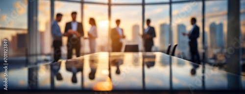Business Team Meeting in a Modern Office at Sunset. Blurred silhouette of a business team having a meeting in a modern office with city skyline photo