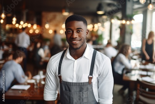 happy african american man waiter in restaurant, cafe or bar photo