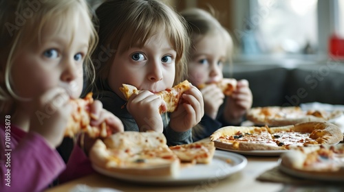 three little girls eating pizza photo