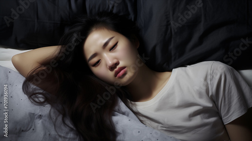 asian woman in bed experimenting headache