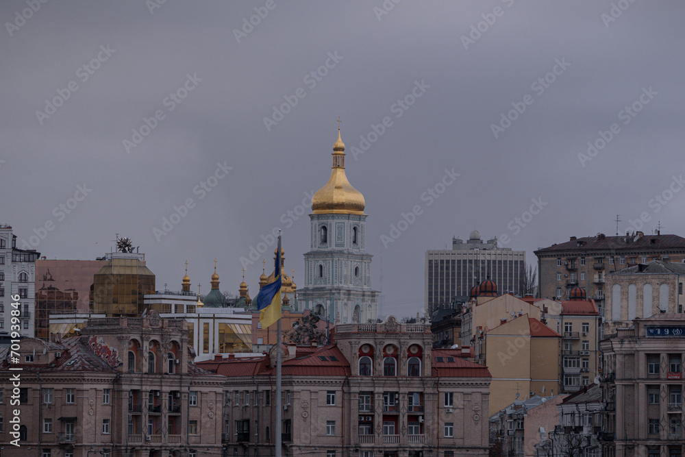 Kyiv, Ukraine - January 2, 2024: beautiful architecture in the city center on Independence Square. There are many cars and people walking. Ukrainian flags are still installed.