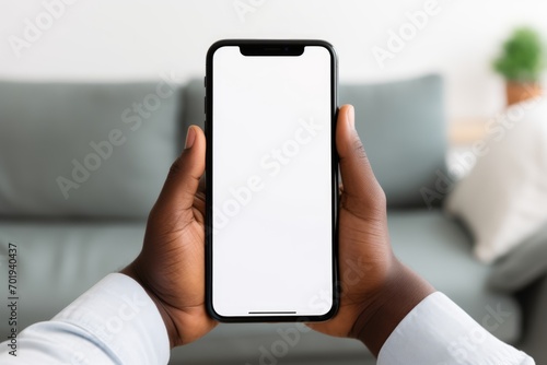 African american man holding smart phone white mockup display, empty screen for app ads. Mobile applications technology concept, close up view